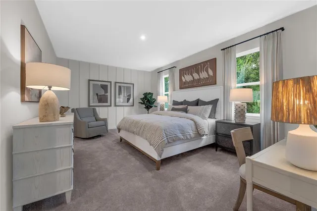 a bedroom with bed and a large mirror next to a window