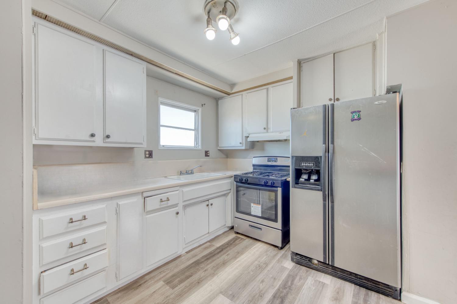 3658 South Butte Avenue Kerman, CA 93630 - Photo 18 of 20 a kitchen with granite countertop cabinets and refrigerator