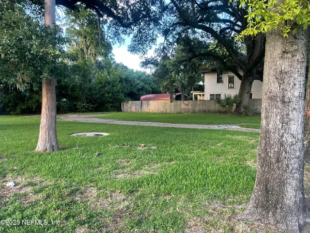 a front view of a house with a yard and trees