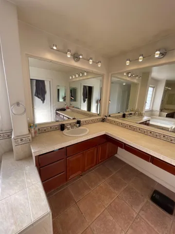a large bathroom with a tub a sink and a large mirror