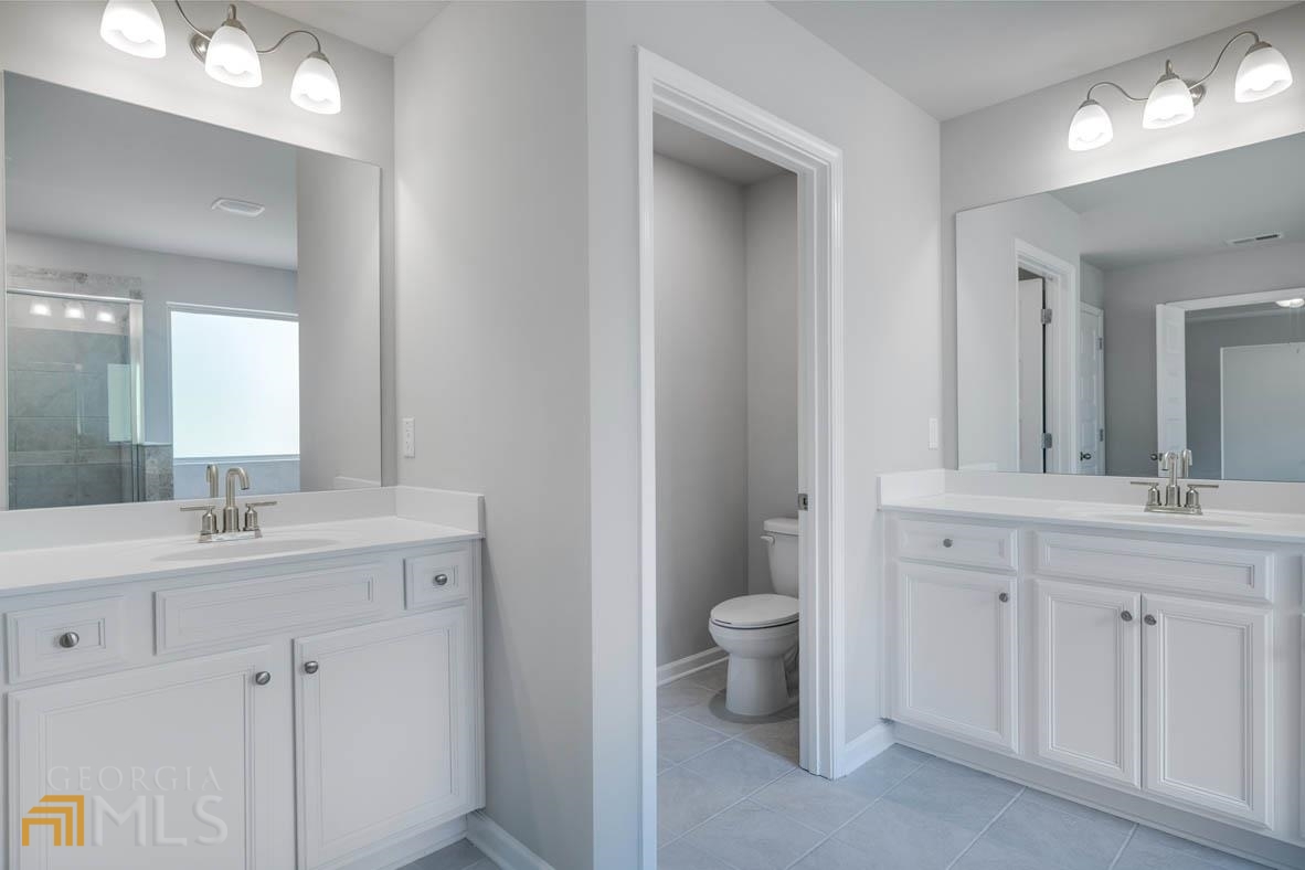 1908 Endress Circle Hampton, GA 30228 - Photo 21 of 44 a bathroom with a toilet sink and mirror