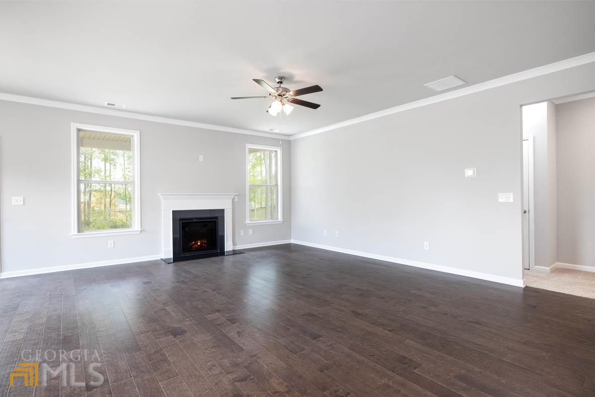 1908 Endress Circle Hampton, GA 30228 - Photo 26 of 44 an empty room with wooden floor fireplace and windows