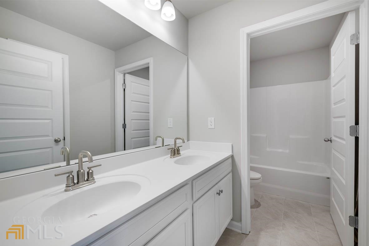 1908 Endress Circle Hampton, GA 30228 - Photo 40 of 44 a bathroom with a sink double vanity granite tub shower and a mirror