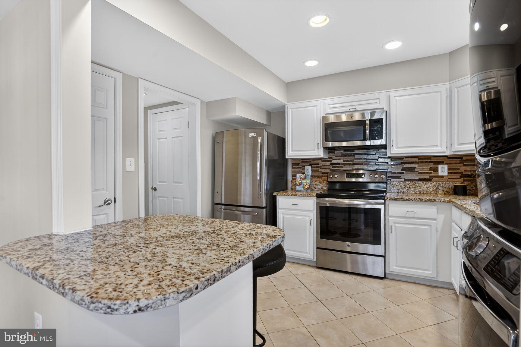6630 Hillandale Road, Unit 56 Chevy Chase, MD 20815 - Photo 20 of 40 a kitchen with stainless steel appliances granite countertop a sink stove and refrigerator