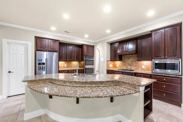 a kitchen with stainless steel appliances granite countertop a sink stove and microwave