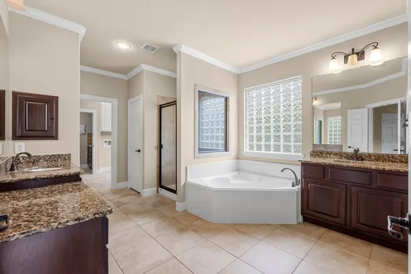 a spacious bathroom with a tub sink and mirror