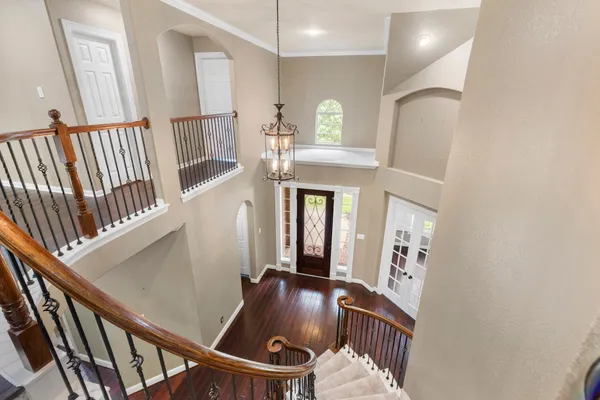 a view of staircase with lots of frames on wall and wooden floor