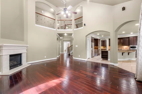 a view of a hallway with wooden floor and a kitchen