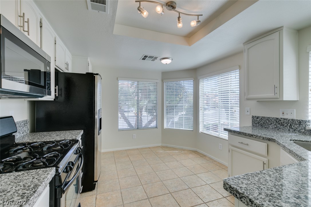 307 Cavalla Street Henderson, NV 89074 - Photo 22 of 44 Granite counters and white cabinetry define this bright kitchen, complete with a cozy eat-in area.