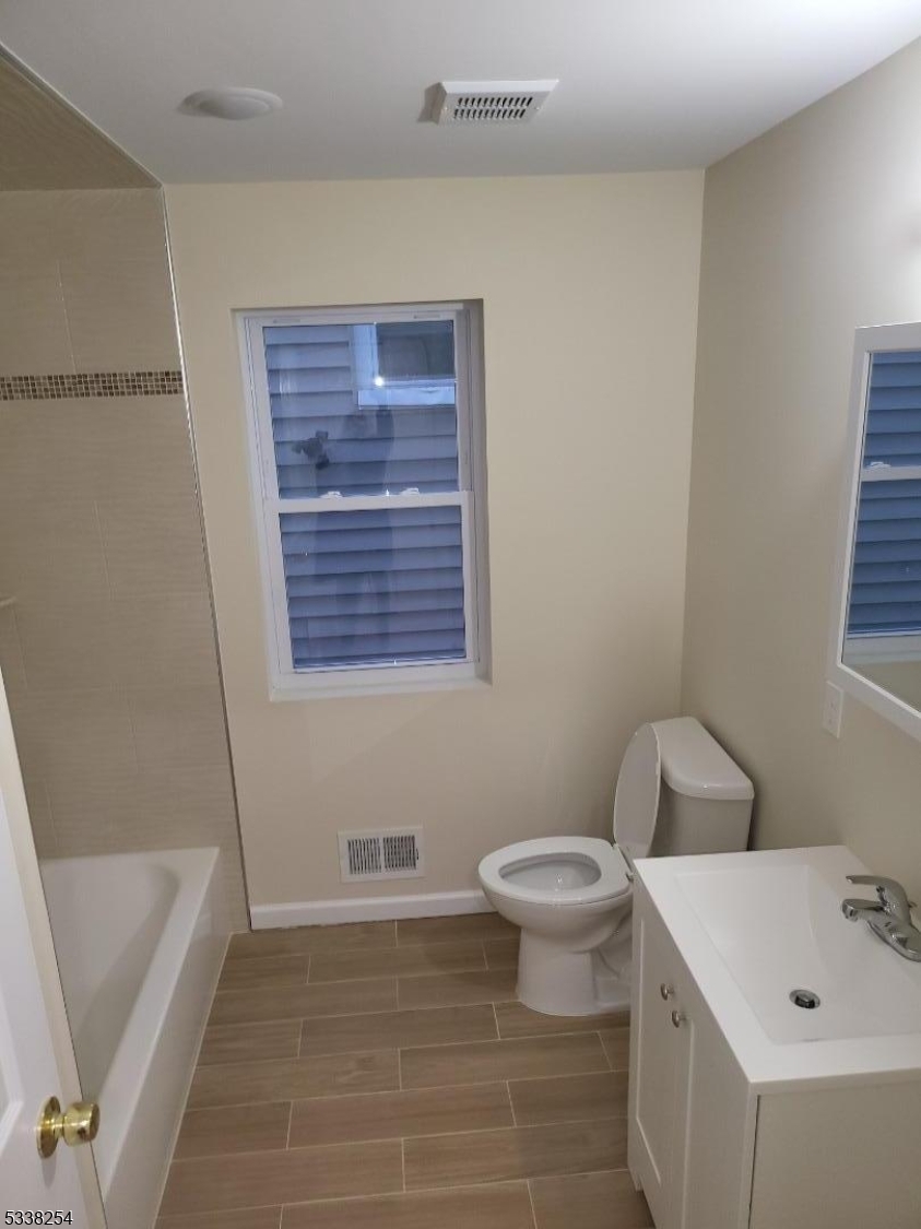 487 South 18th Street, Unit 1 Newark, NJ 07103 - Photo 11 of 22 a bathroom with a sink a toilet and shower