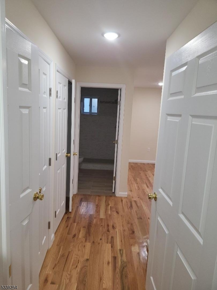 487 South 18th Street, Unit 1 Newark, NJ 07103 - Photo 16 of 22 a view of a hallway with wooden floor and a bathroom