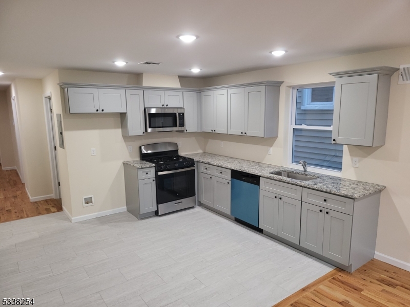 487 South 18th Street, Unit 1 Newark, NJ 07103 - Photo 4 of 22 a kitchen with stainless steel appliances granite countertop a stove a sink and a refrigerator