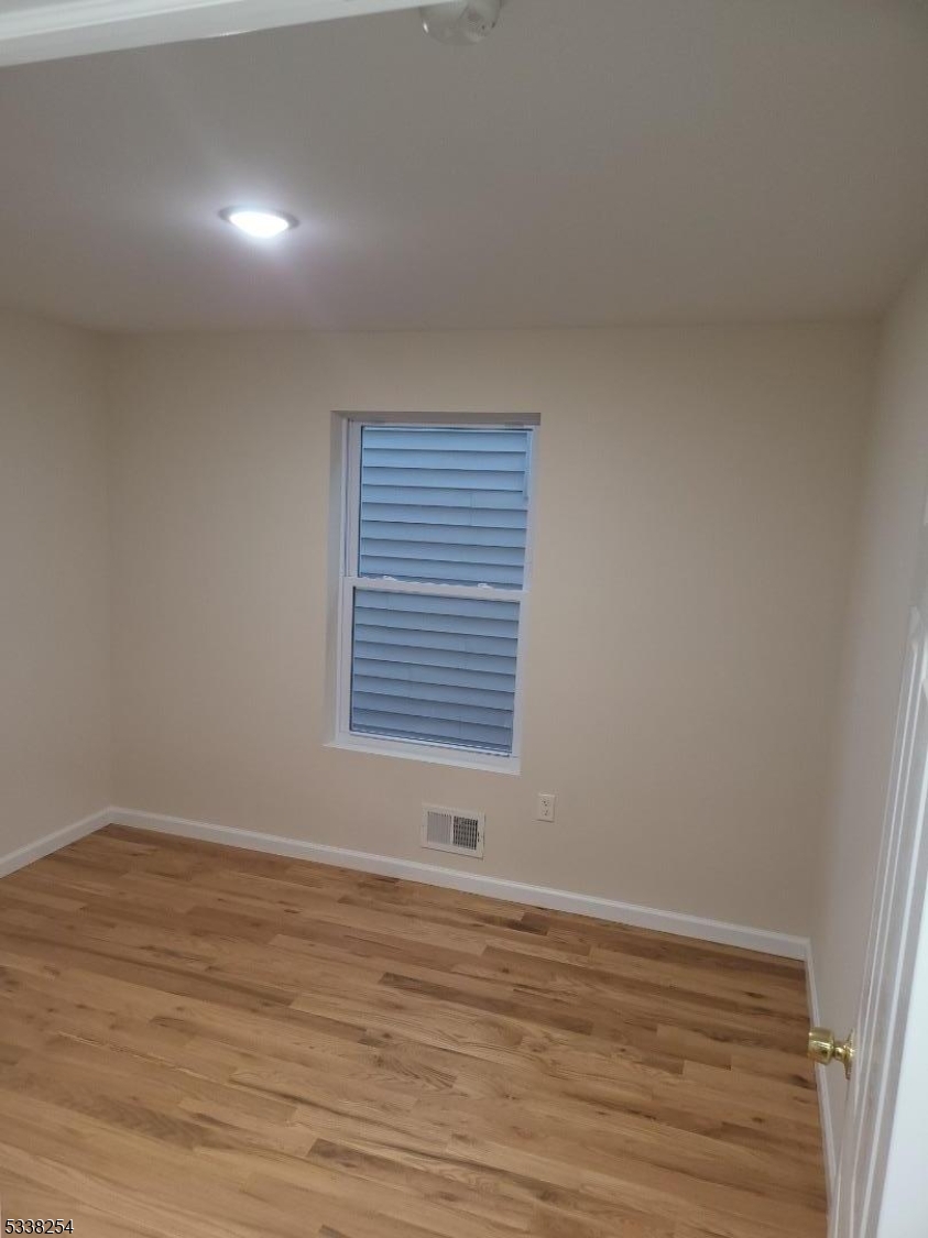 487 South 18th Street, Unit 1 Newark, NJ 07103 - Photo 9 of 22 a view of an empty room with wooden floor and a window