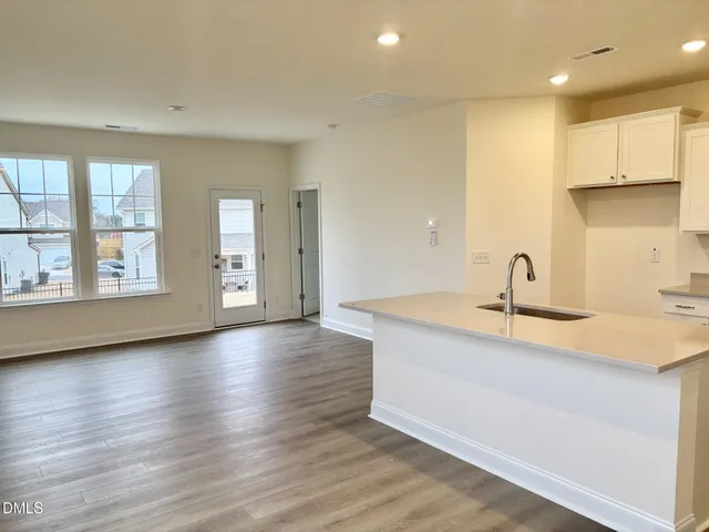 a view of a kitchen with wooden floor and a sink