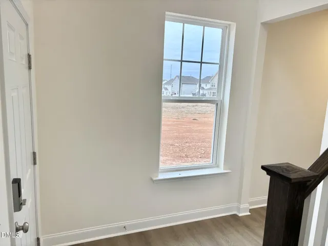an entryway with wooden floor and staircase