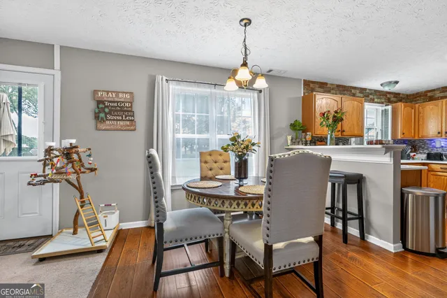 a dining room with furniture a chandelier and wooden floor