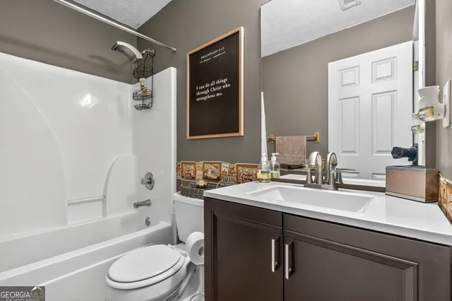 a bathroom with a sink toilet vanity tub and shower