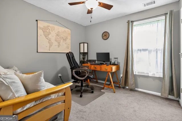 a view of a workspace with furniture and a window