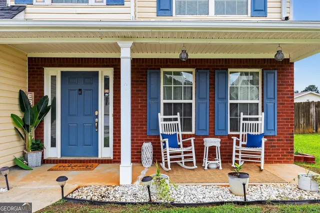 a view of front door of house with outdoor seating