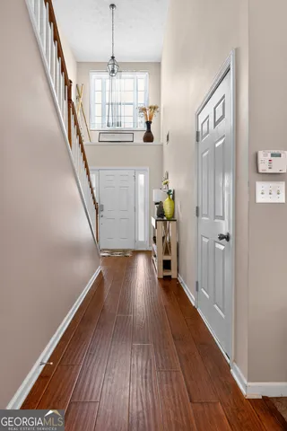 a view of hallway with wooden floor and stairs