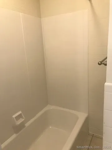 a bathroom with a granite countertop toilet and a bathtub