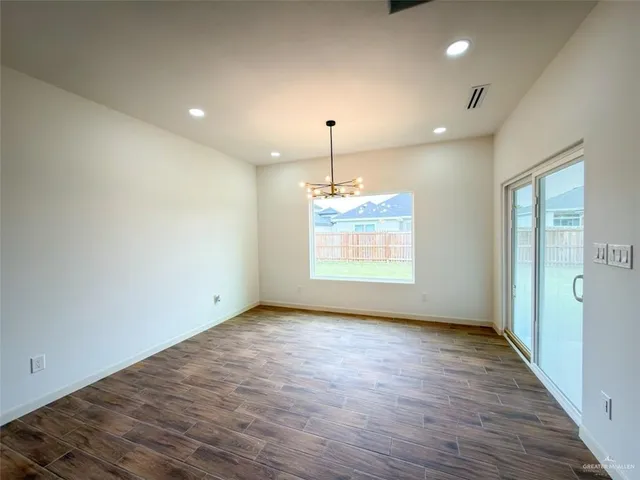 a large kitchen with stainless steel appliances kitchen island granite countertop a stove a sink and white cabinets