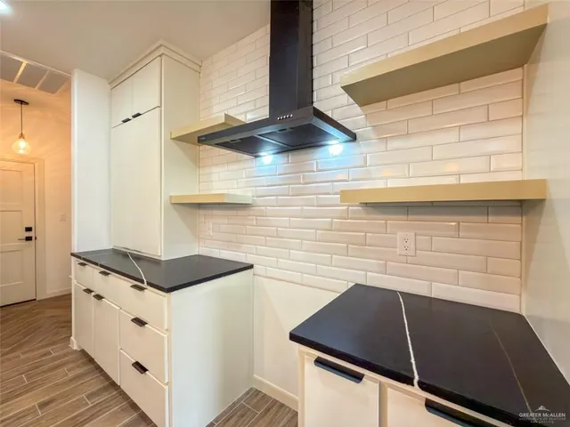 a kitchen with stainless steel appliances granite countertop a sink a stove and a wooden floor