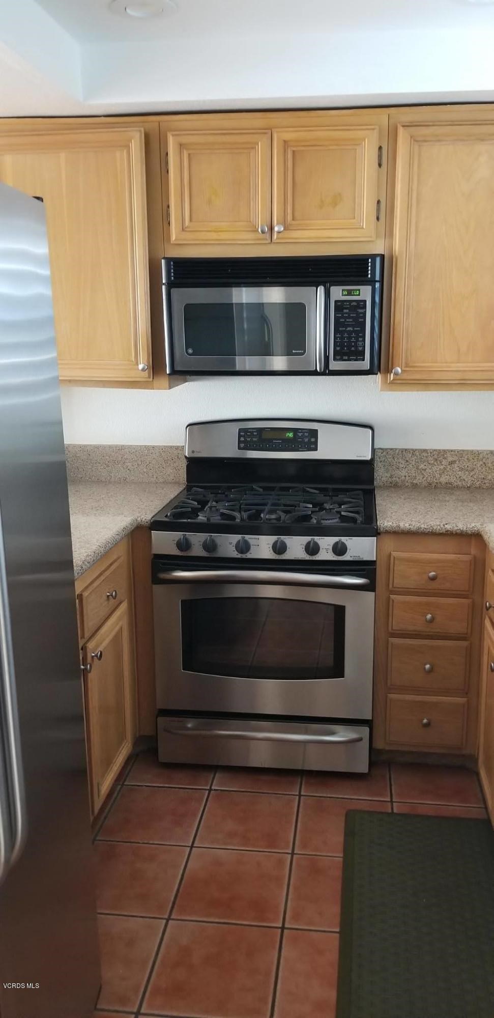 2731 Erringer Road, Unit 71 Simi Valley, CA 93065 - Photo 3 of 45 a kitchen with granite countertop a stove and a microwave