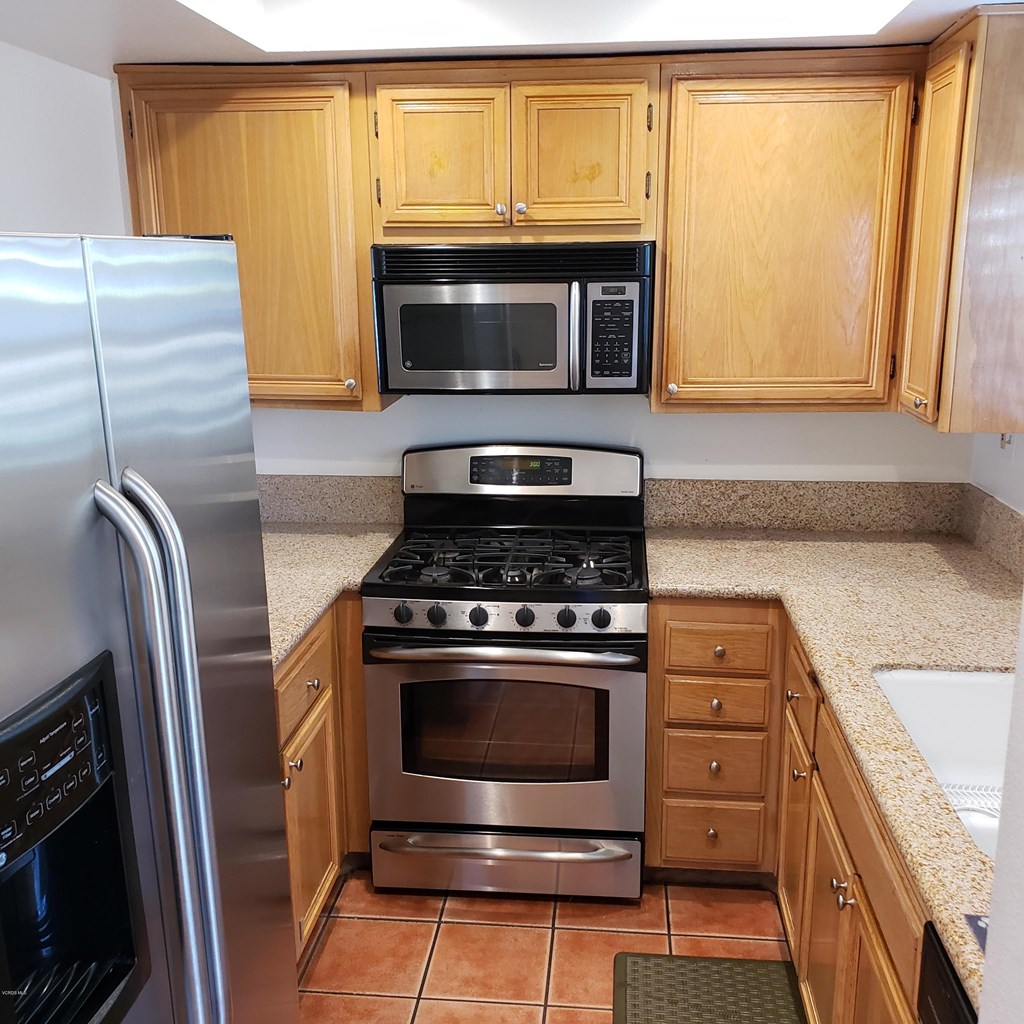 2731 Erringer Road, Unit 71 Simi Valley, CA 93065 - Photo 5 of 45 a kitchen with granite countertop a sink stove and microwave