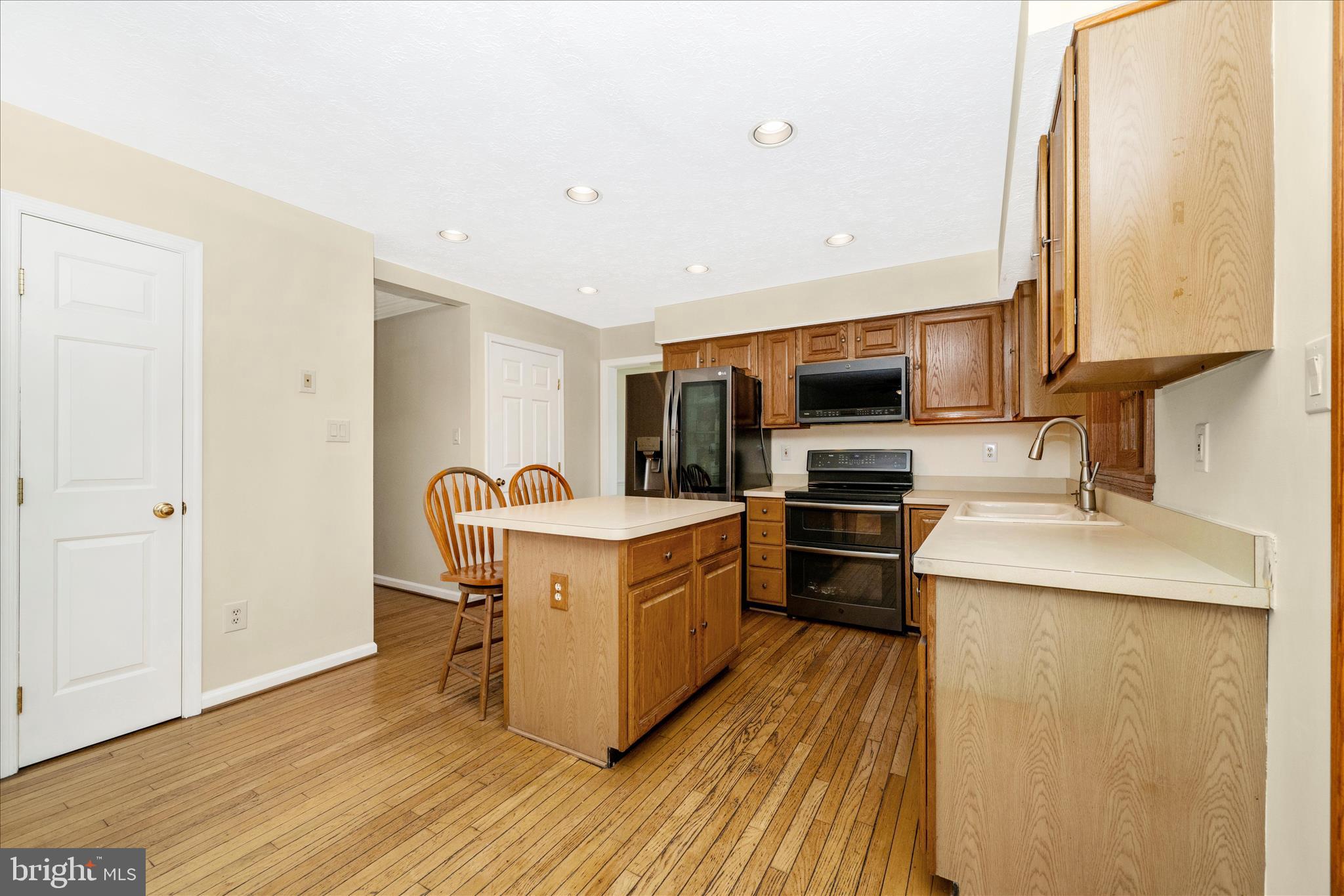 9534 Liberty Road Frederick, MD 21701 - Photo 18 of 70 a kitchen with stainless steel appliances granite countertop a stove top oven a sink dishwasher and a refrigerator with wooden floor