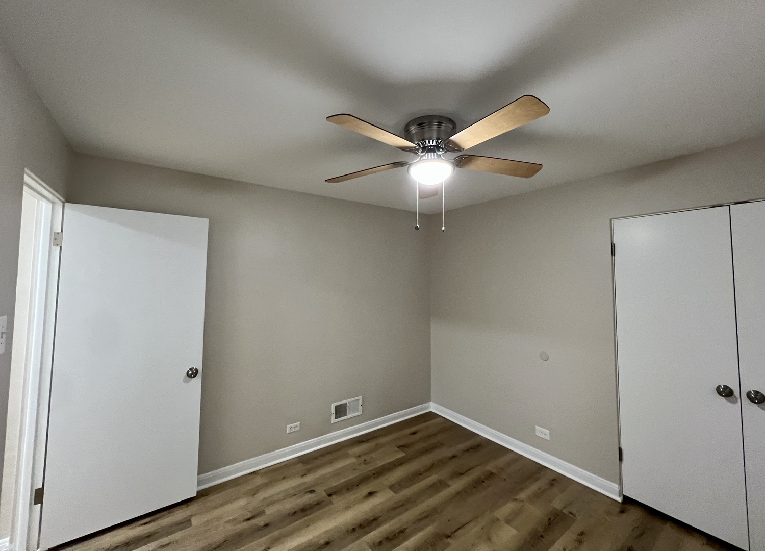 1515 Maple Avenue, Unit 1 Berwyn, IL 60402 - Photo 6 of 12 an empty room with wooden floor and fan