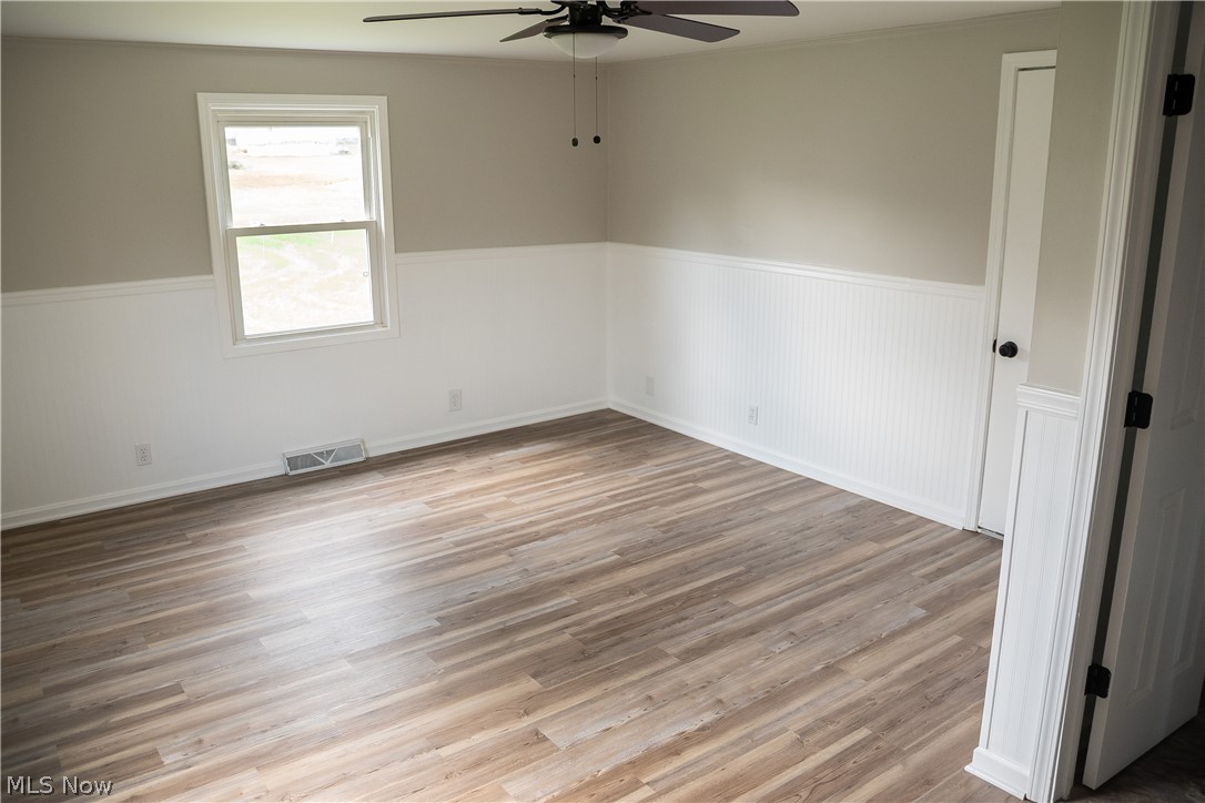 6666 Clingan Road Youngstown, OH 44514 - Photo 24 of 41 Family room with new ceiling fan, wainscoting, hald bathroom and exit to back patio