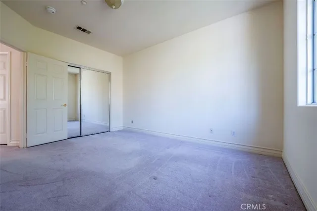 an empty room with windows and closet