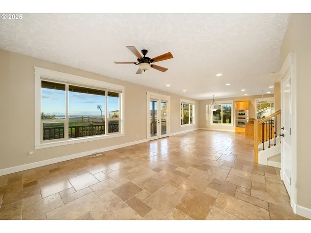 a view of an empty room and kitchen view