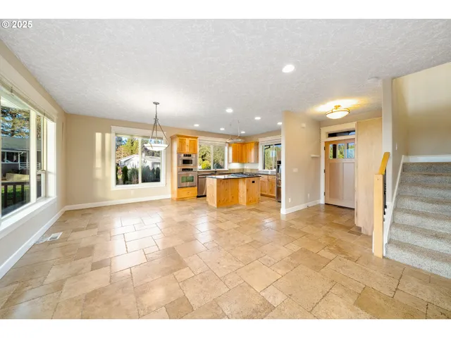 a kitchen with stainless steel appliances granite countertop a stove a sink and a refrigerator
