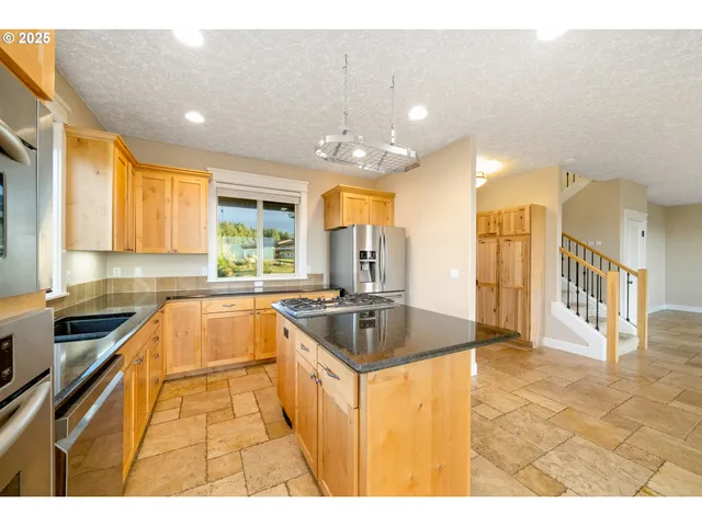 a kitchen with stainless steel appliances a stove a sink and a counter top space