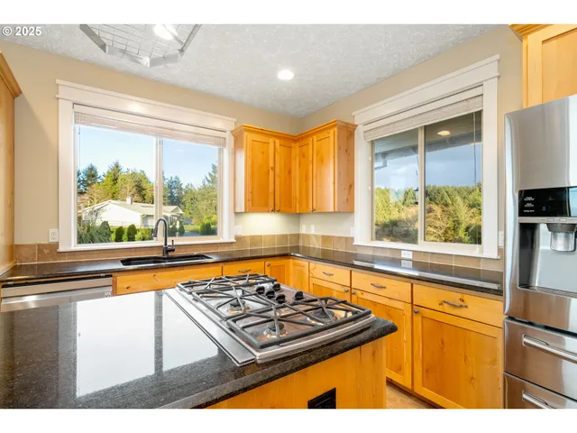 a kitchen with kitchen island a large counter top space appliances and a chandelier