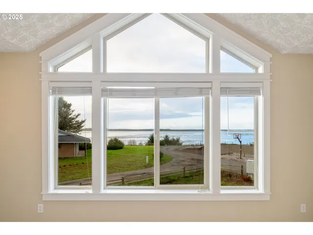 an empty room with windows and ceiling fan