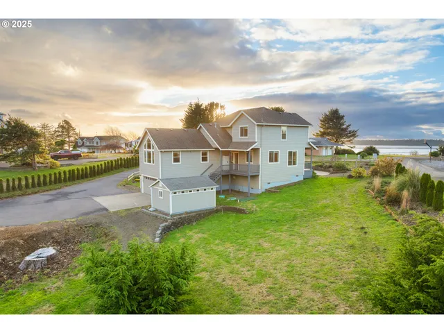 a view of a house with a big yard and large trees