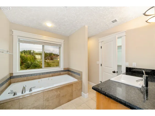 a white bath tub sitting in a bathroom next to a window