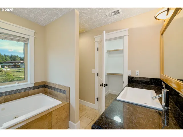 a bathroom with a granite countertop sink and a toilet