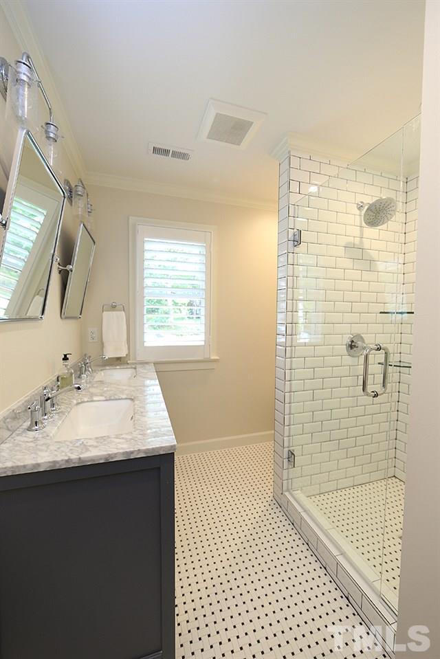 7828 Hardwick Drive Raleigh, NC 27615 - Photo 19 of 25 a bathroom with a granite countertop sink a shower and a mirror
