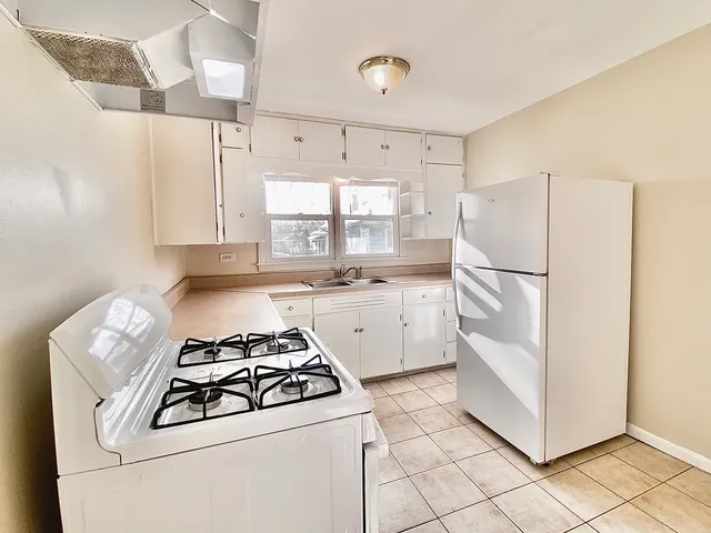 a kitchen with a stove a refrigerator and a sink