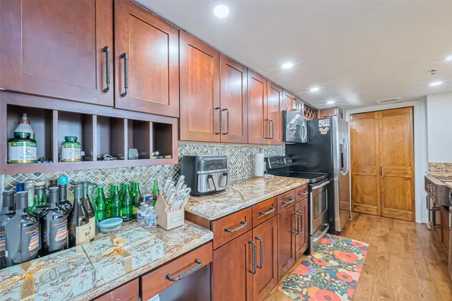 a kitchen with stainless steel appliances granite countertop a sink stove and refrigerator