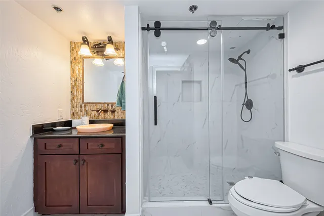 a bathroom with a sink a toilet and shower