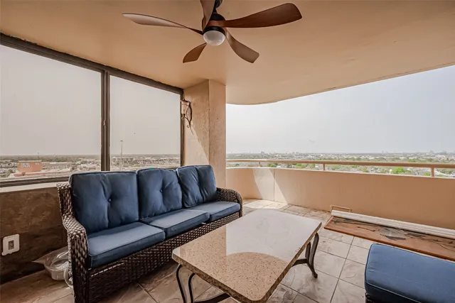 a living room with stainless steel appliances furniture and a kitchen view