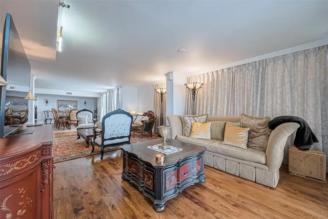 a living room with furniture a flat screen tv and kitchen view