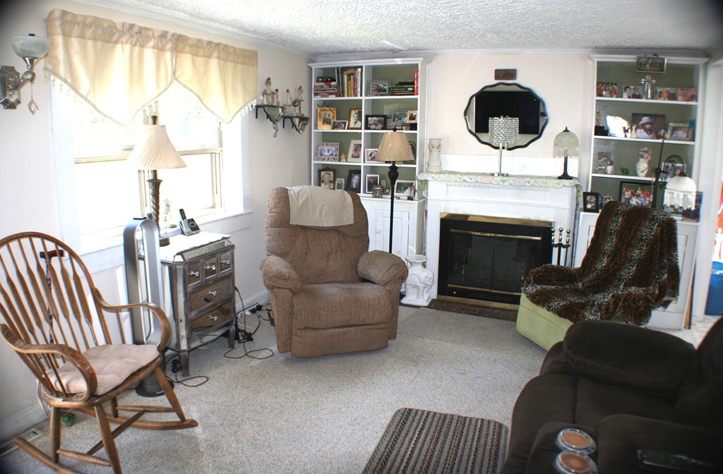 39 Lathrop Road Bourne, MA 02562 - Photo 4 of 22 a living room with furniture a fireplace and a large window