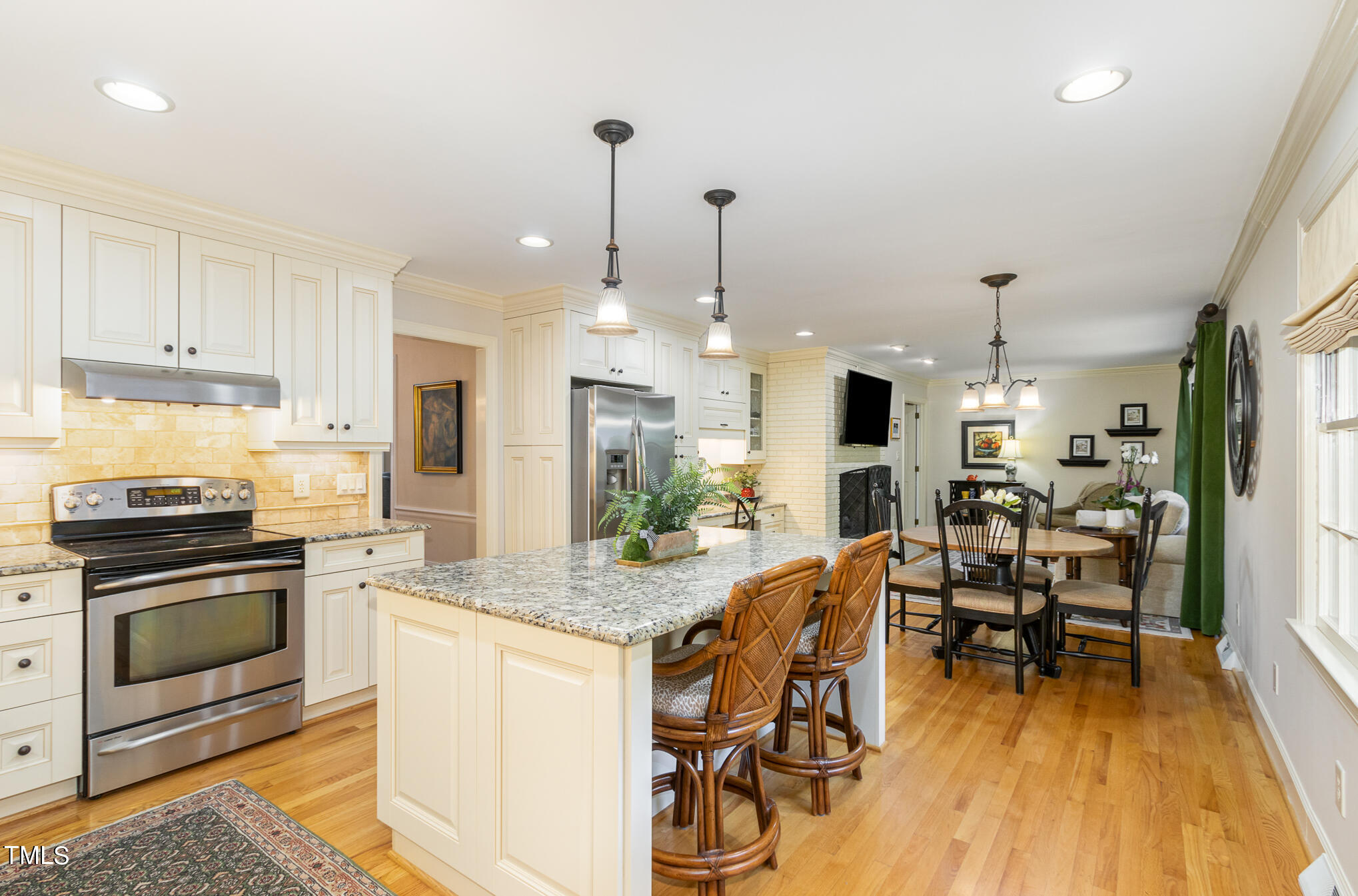 2901 Augusta Court Raleigh, NC 27607 - Photo 7 of 28 a open kitchen with stainless steel appliances granite countertop a stove top oven a sink dishwasher a dining table and chairs with wooden floor