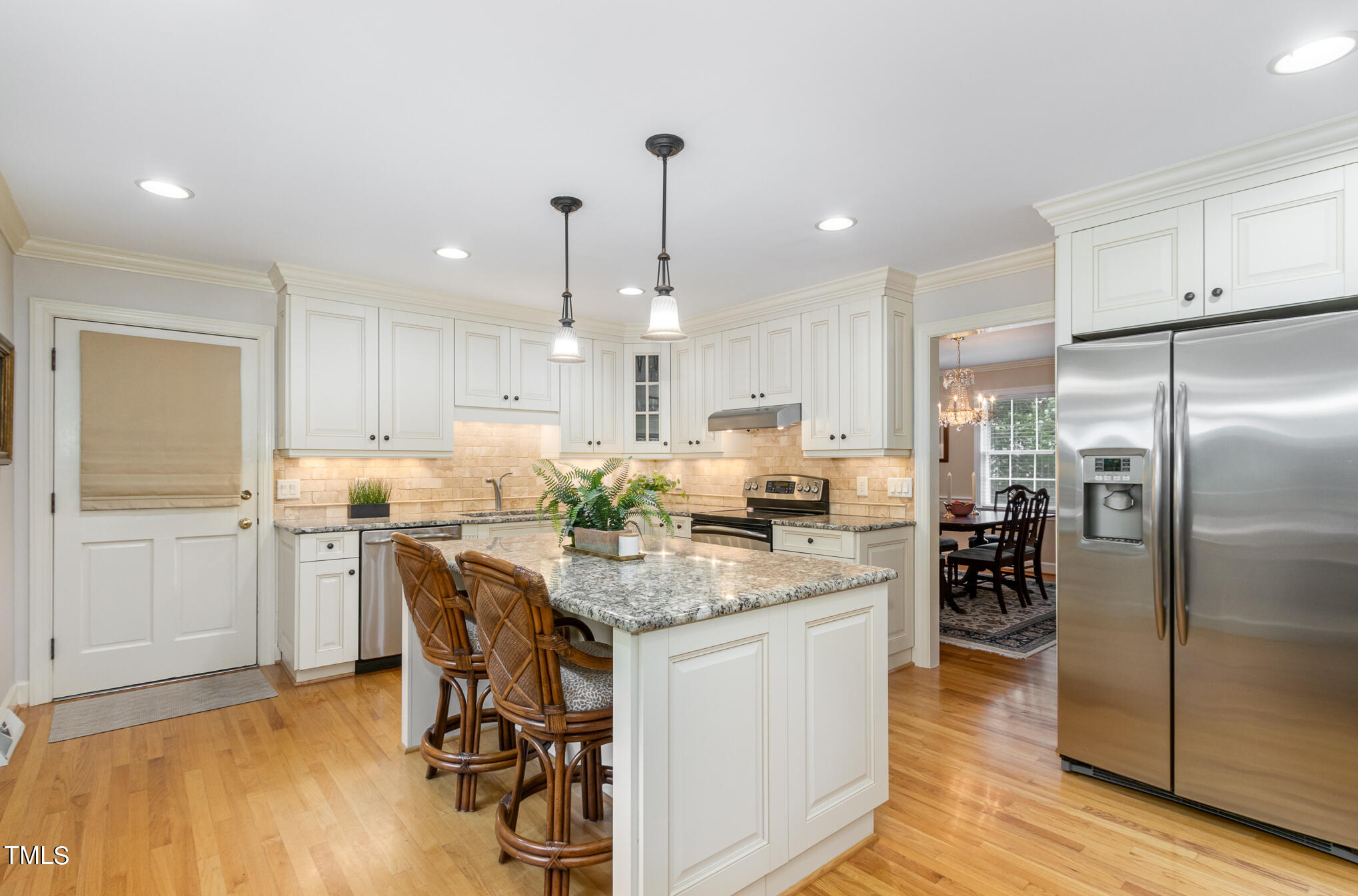 2901 Augusta Court Raleigh, NC 27607 - Photo 10 of 28 a kitchen with stainless steel appliances kitchen island granite countertop a dining table chairs stove refrigerator and cabinets